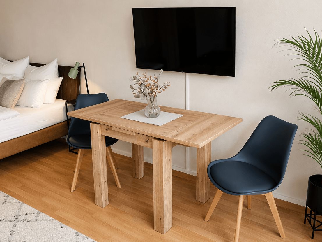 Essbereich mit Holztisch und gepolsterten Stühlen im möblierten Apartment Zschertnitz